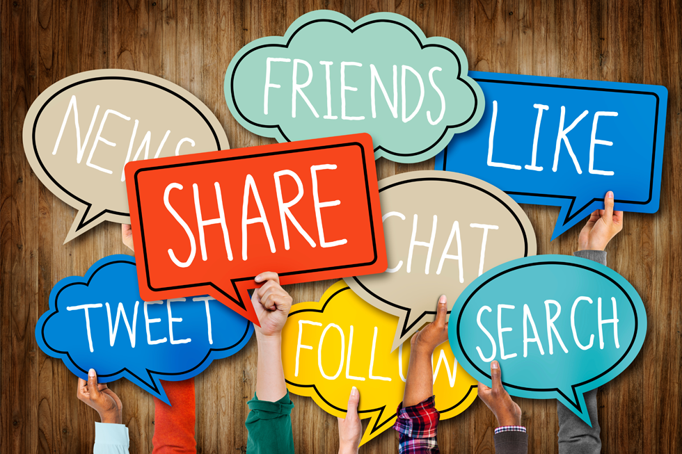 Hands are holding up colorful speech bubbles that say friends, like, news, share, chat, search, tweet and follow.