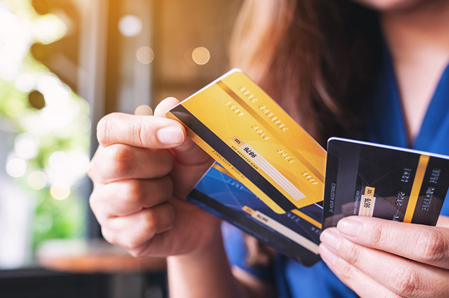 Image Shows a Person Holding Three Credit Cards.